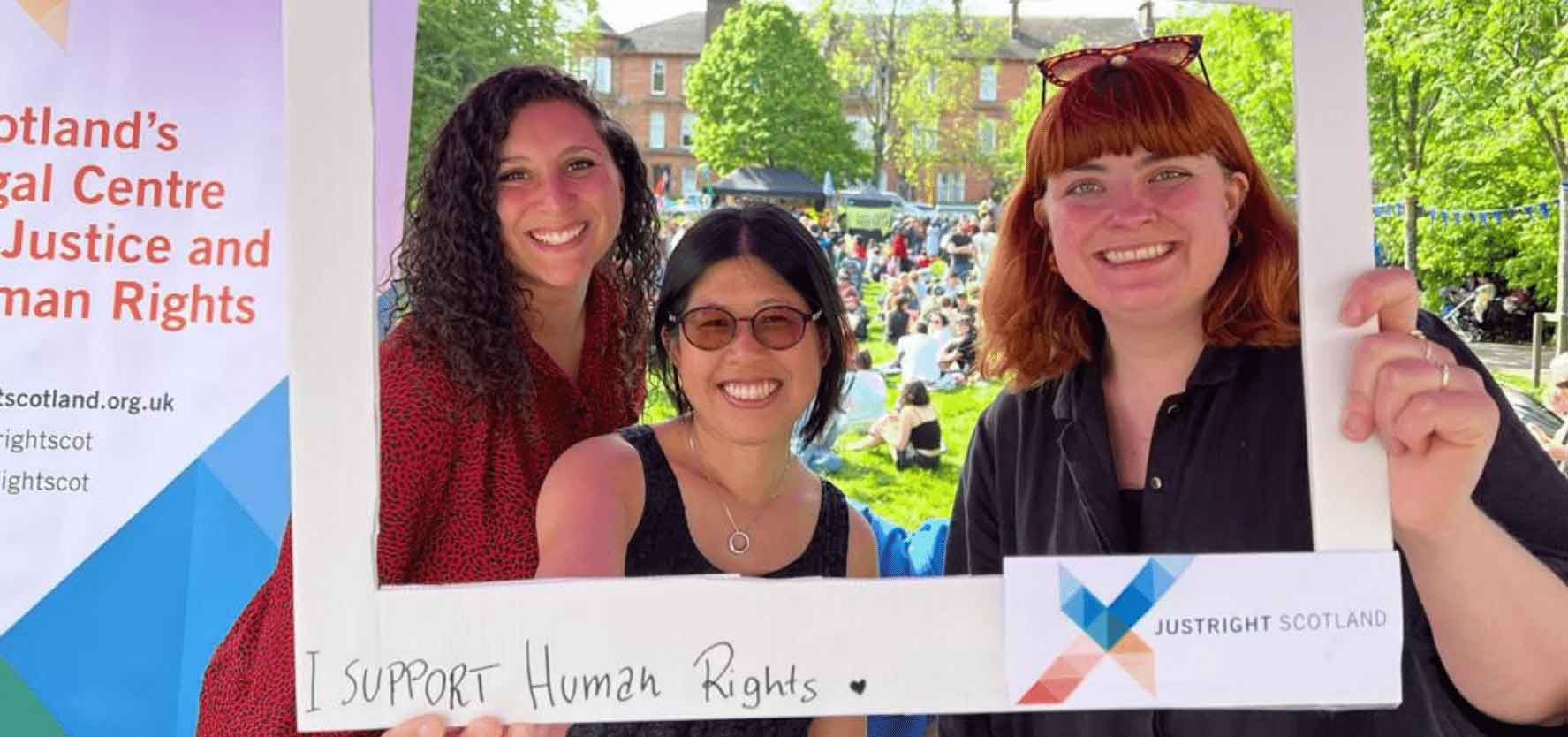 Three members of the Just Right Scotland team pose for a picture in a frame which reads 'I support huamn rights'. Picture: JustRight Scotland