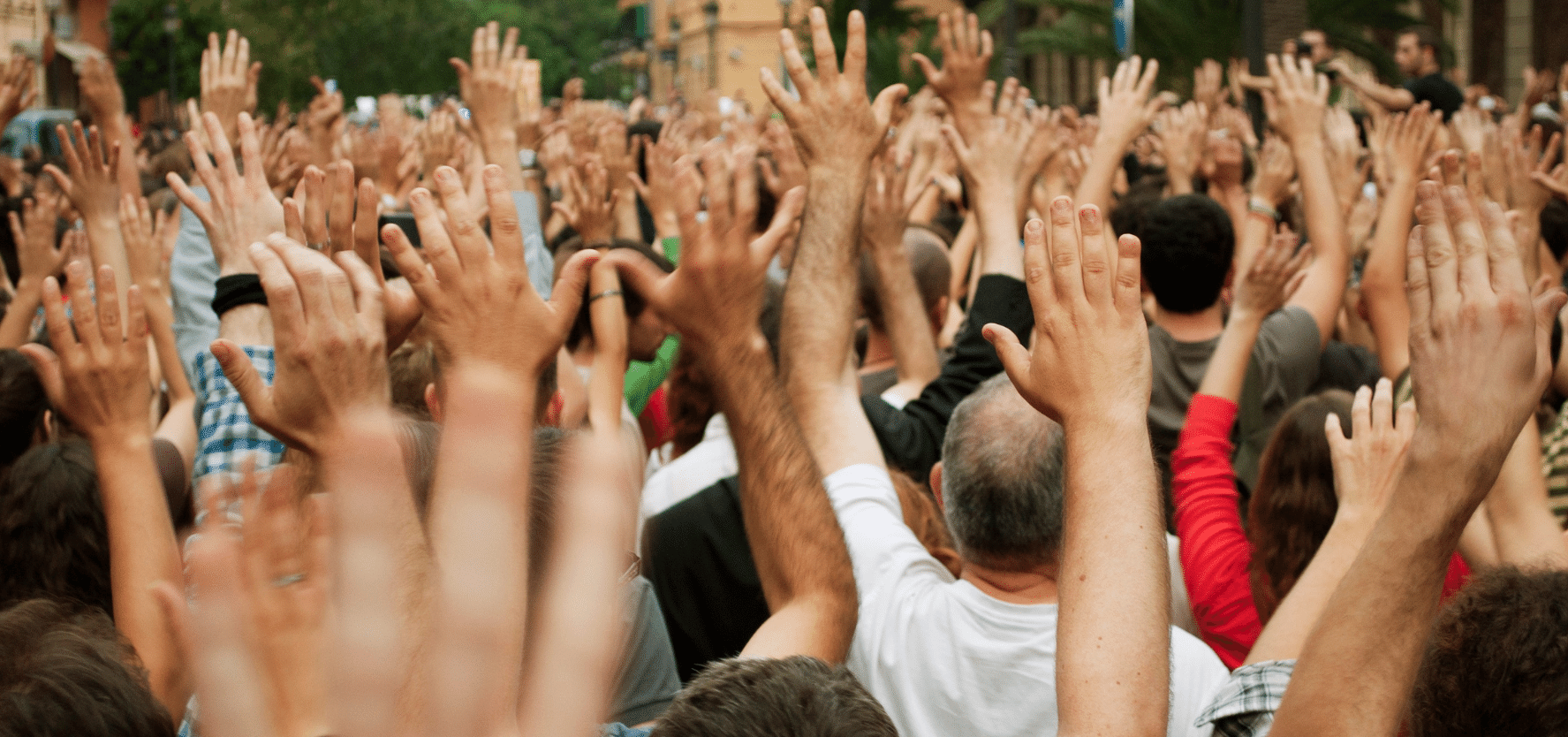 A crowd of people are pictured with their hands raised in the air in pacific demonstration. Picture: Lalocracio, iStock